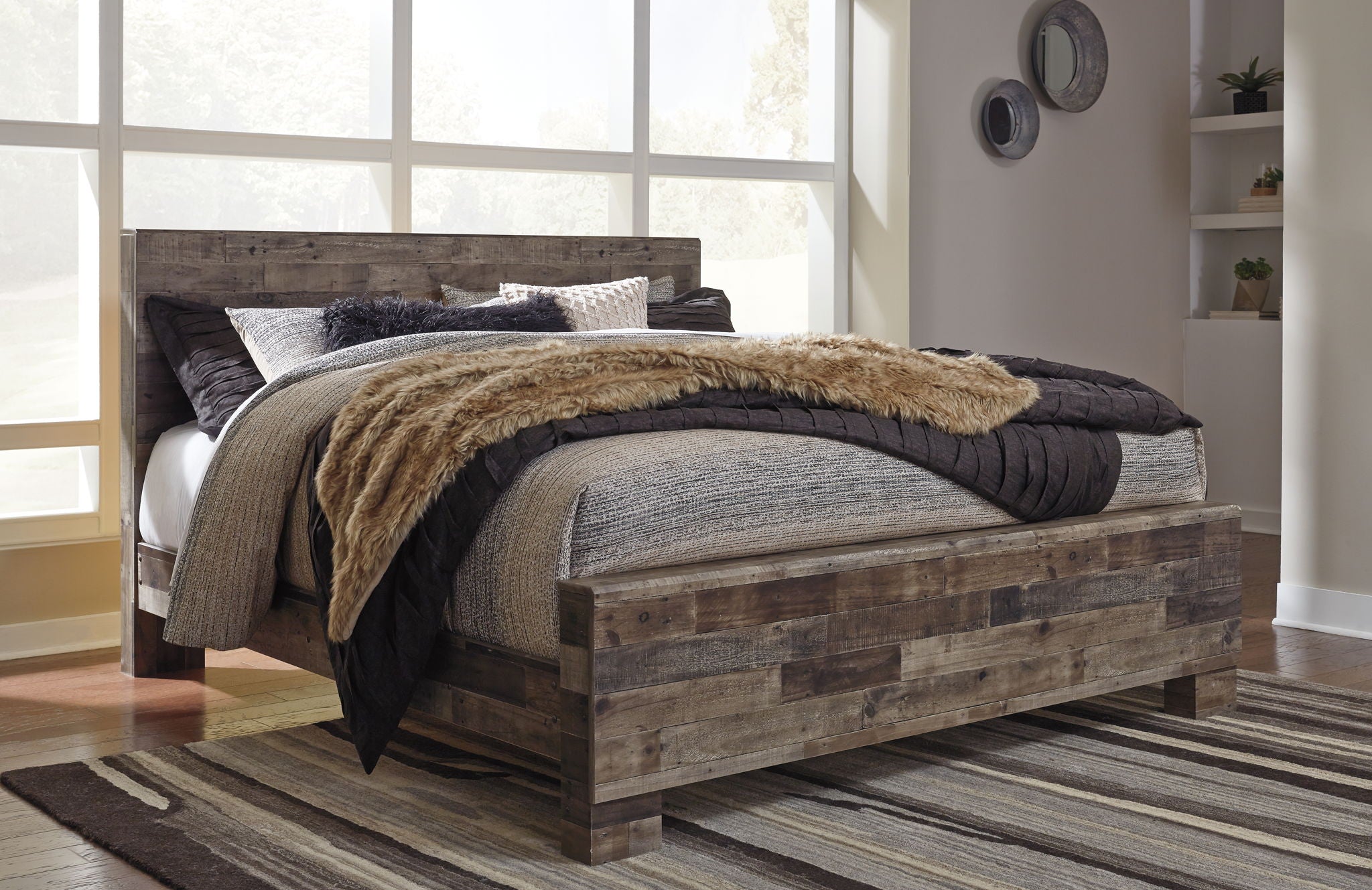 Rustic panel bed with dark wood frame, layered bedding with black and gray covers