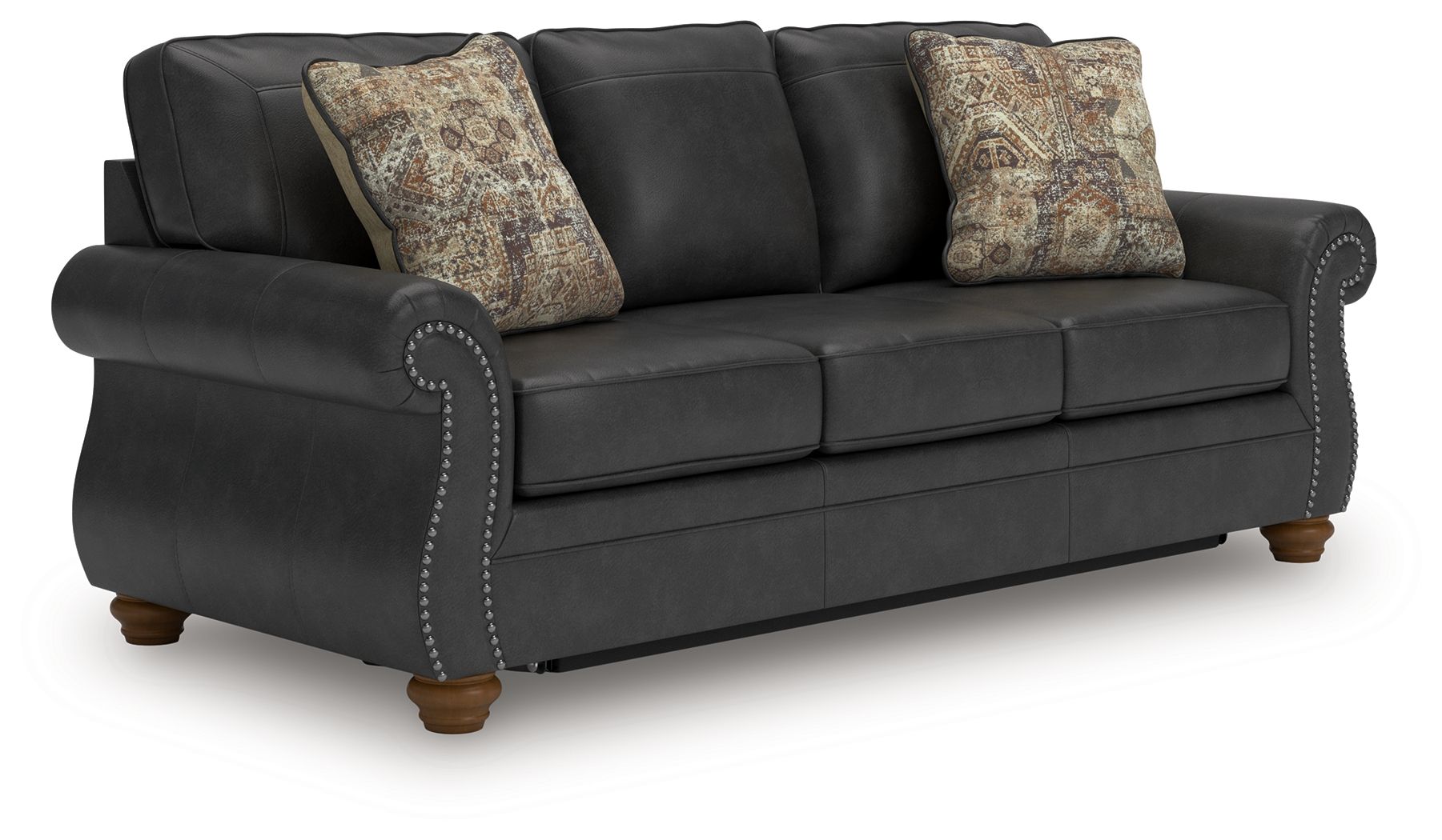 Dark gray sofa sleeper with tufted back, decorative nailhead trim, and two patterned pillows
