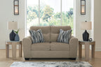 Light brown upholstered loveseat with two seat cushions and striped throw pillows