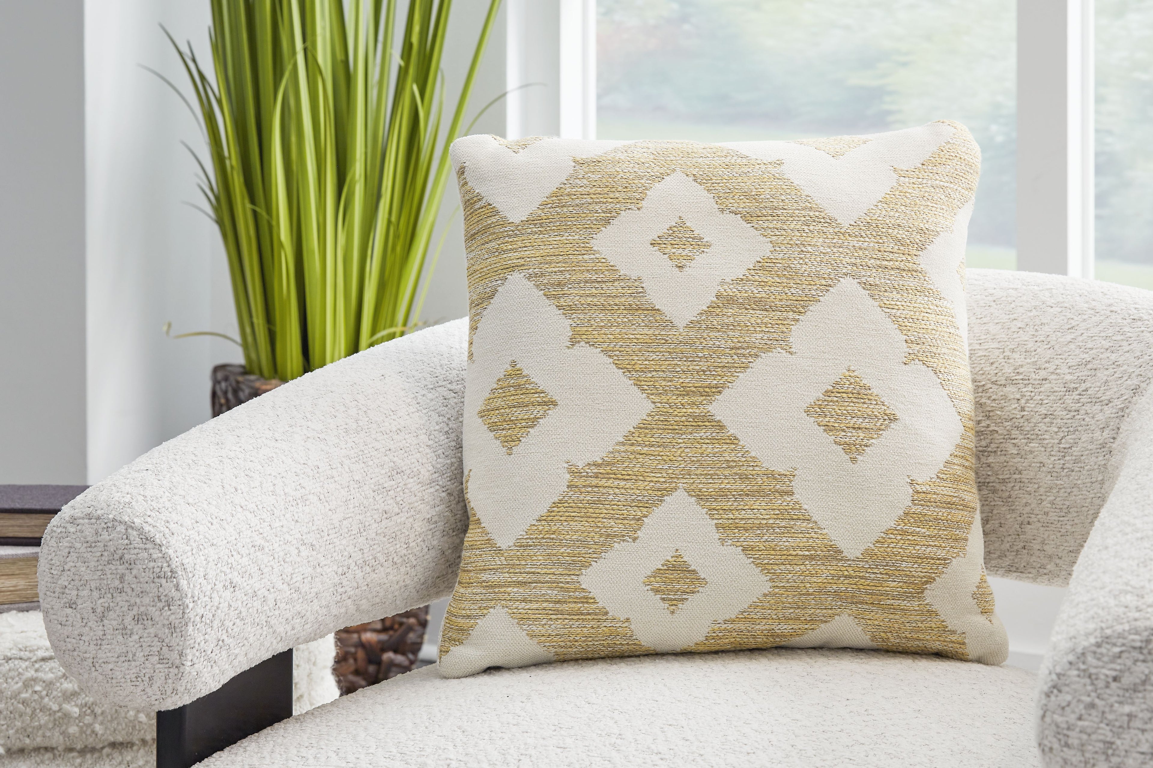 Light brown decorative pillow with diamond pattern in white and metallic gold