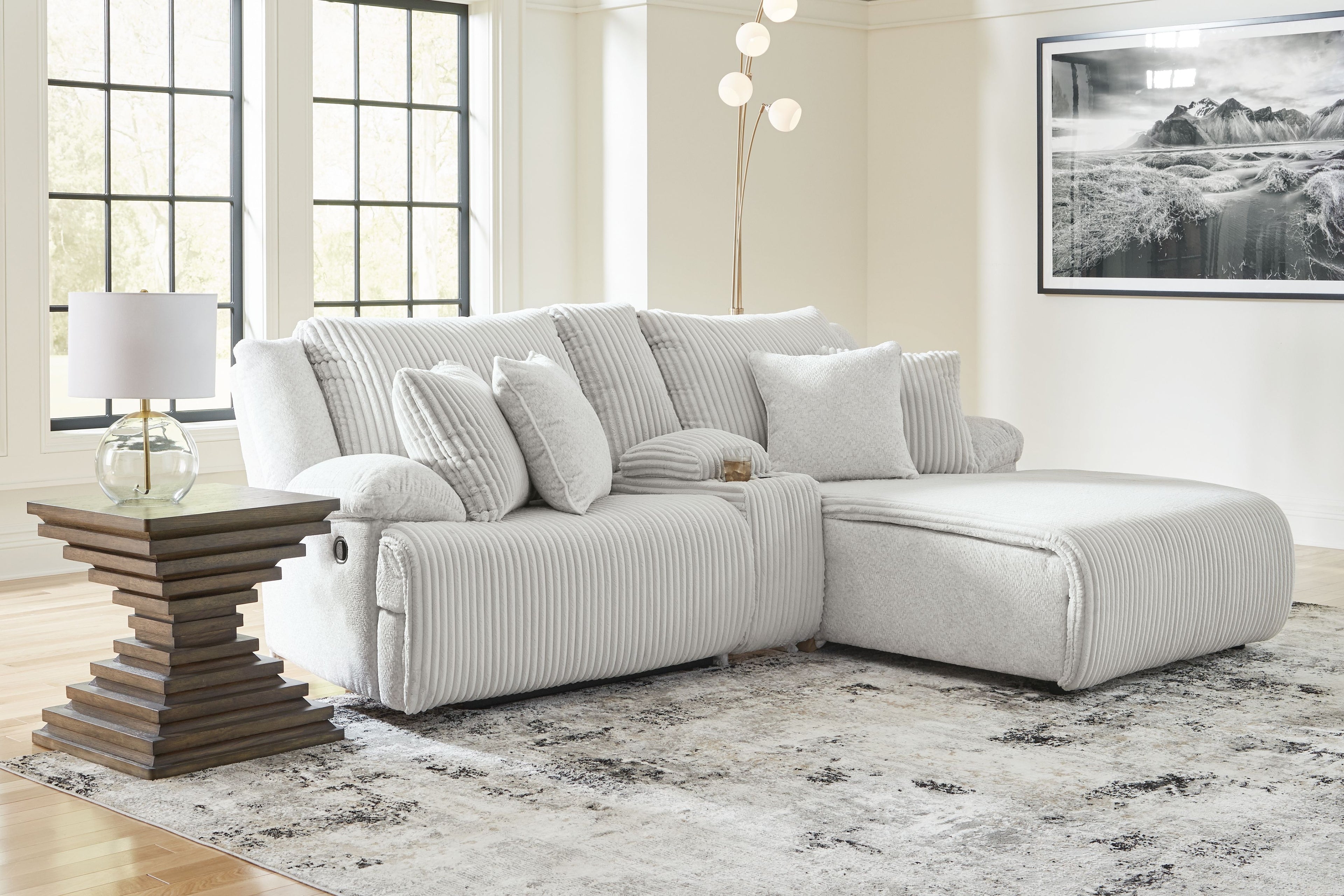 Light gray corduroy-style reclining sectional sofa with chaise and stacked back pillows