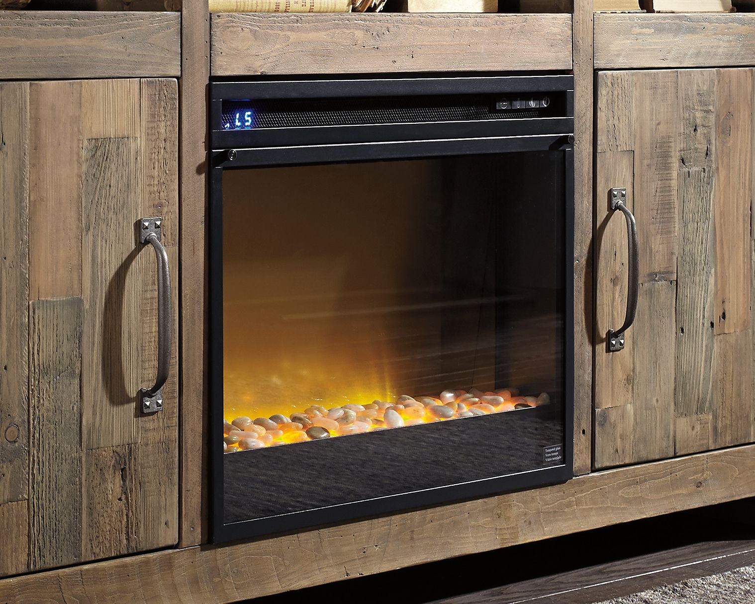 Black fireplace insert set into a wooden cabinet with glass front and glowing flame