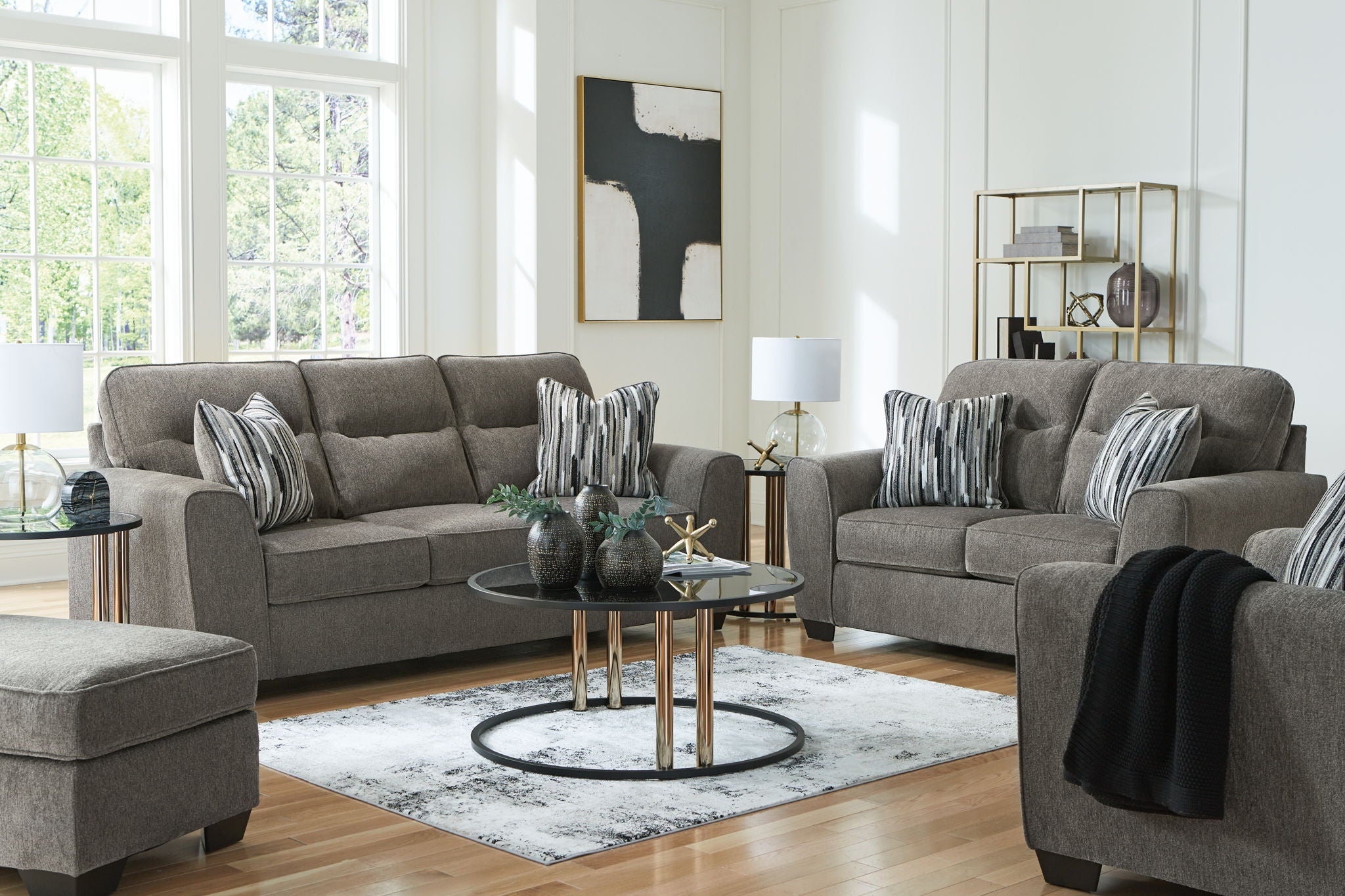 Dark gray fabric sofa and chair set with striped throw pillows and ottoman