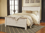 Beige panel bed with slatted panels and low footboard, striped bedding