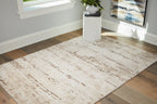 Beige area rug with distressed stripe bands, laid flat with low pile.