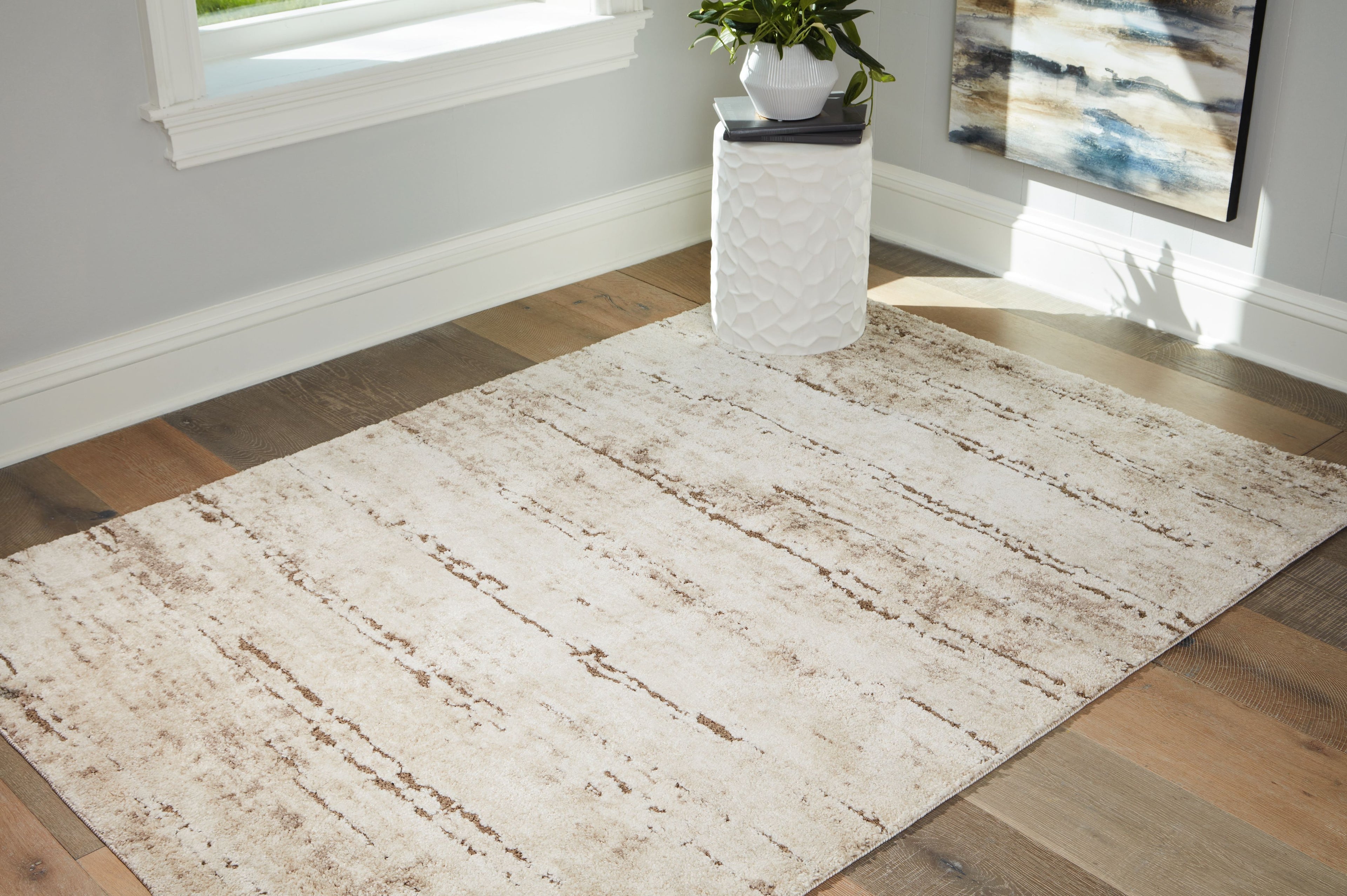 Beige area rug with distressed stripe bands, laid flat with low pile.