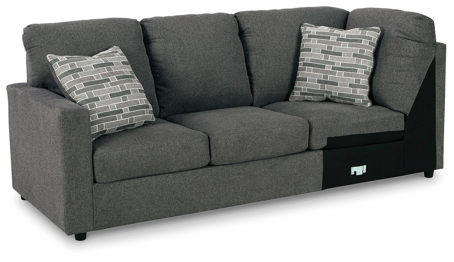 Dark gray wedge sofa with three seat cushions and two patterned throw pillows