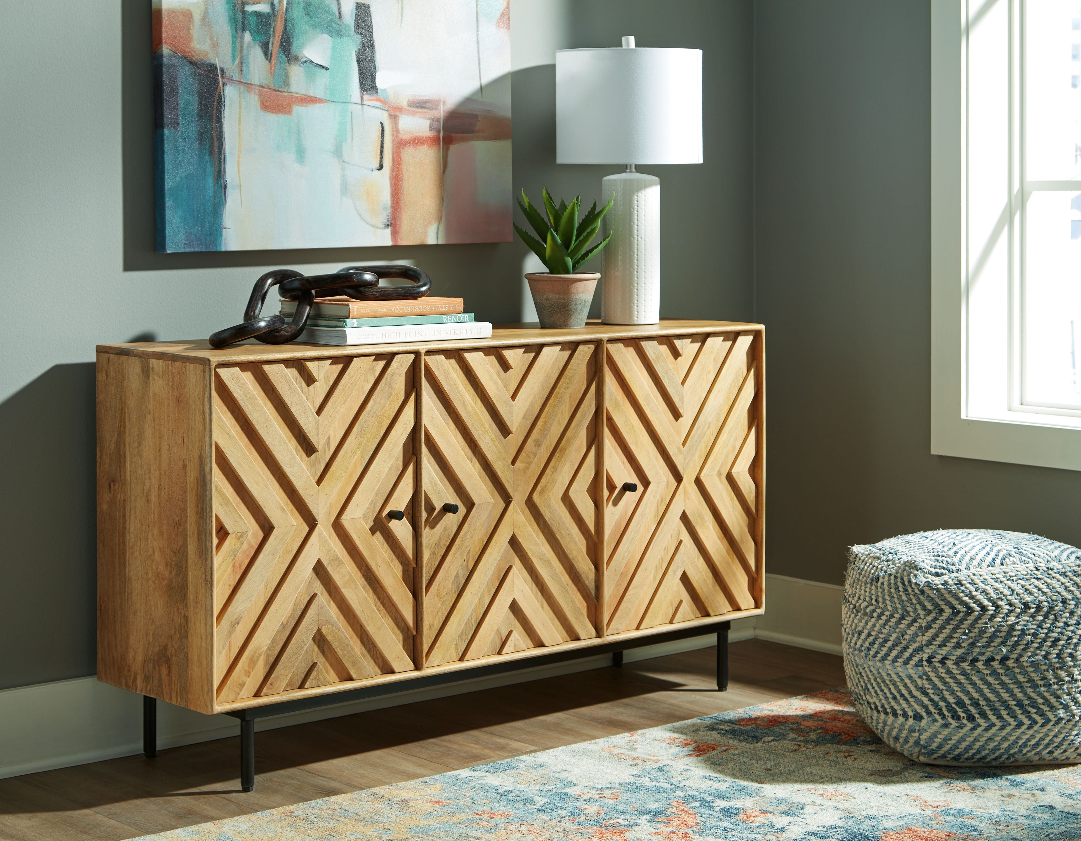 Natural wood accent cabinet with geometric chevron doors and black tapered legs