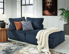 Navy modular sectional sofa with chaise, decorative pillows, and draped throw