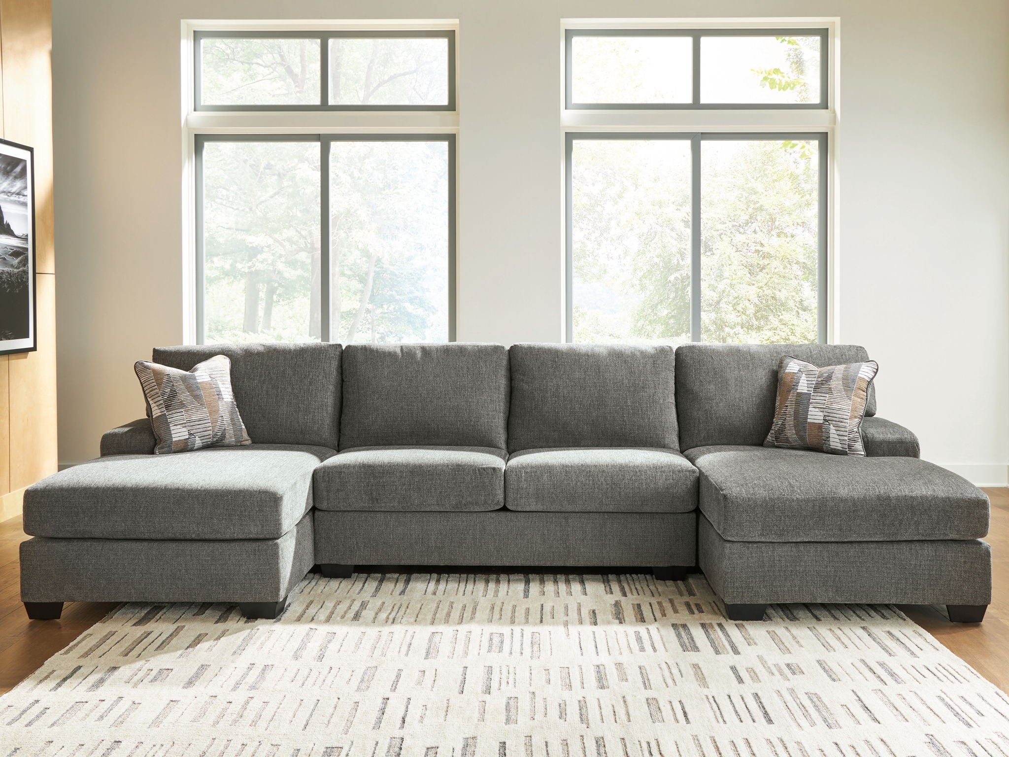 Gray sectional sofa with chaise, rounded seat cushions, and patterned accent pillows