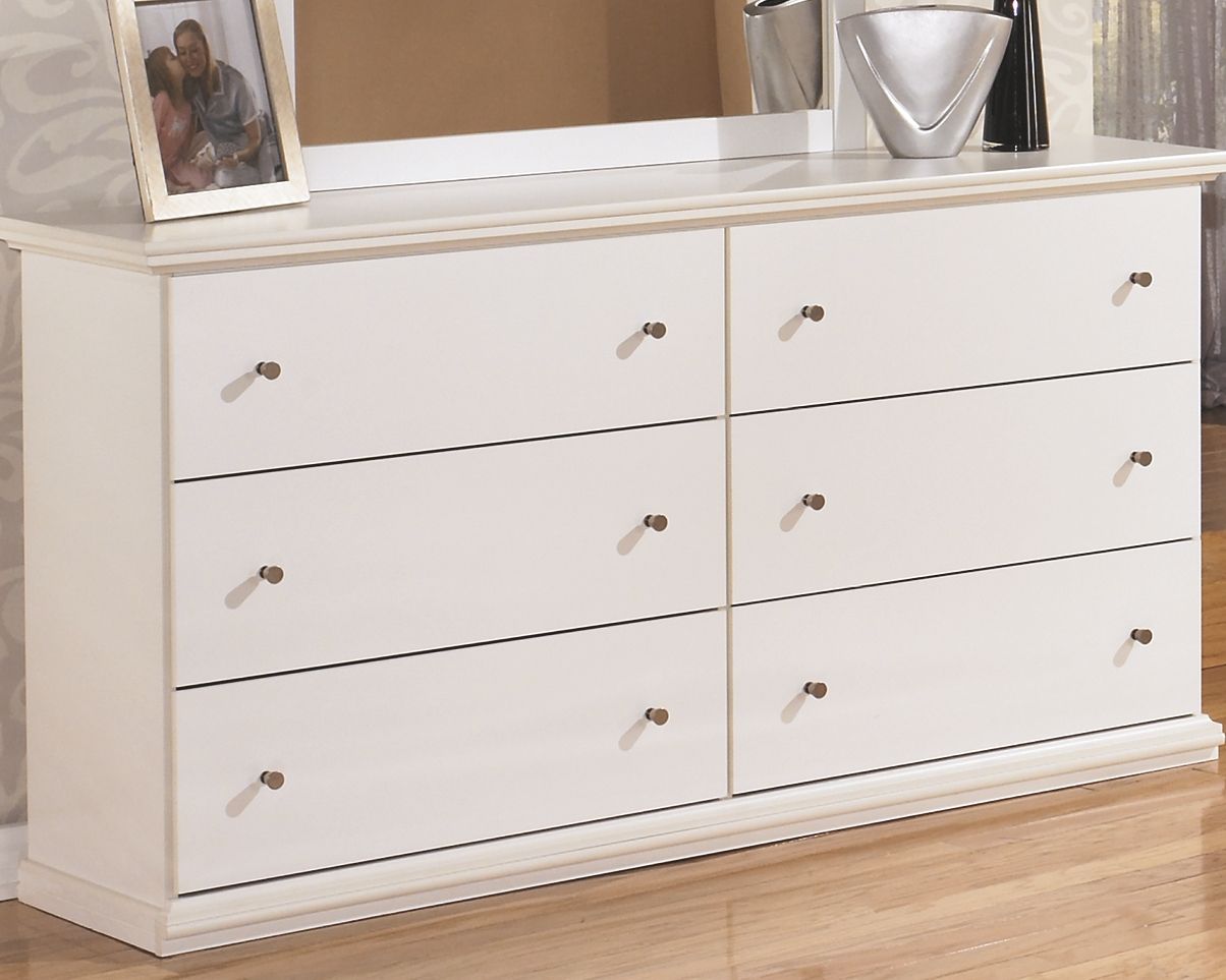White dresser with six drawers and brass knobs, shown from front corner