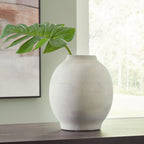 Cream ceramic vase with rounded silhouette and short flared neck, speckled texture.