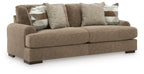 Brown sofa and loveseat set with patterned and textured throw pillows