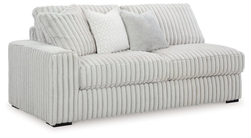 Light gray corded sofa with ribbed upholstery, rounded arms, and two accent cushions
