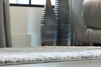 Dark gray area rug with low pile and visible border edging, corner view