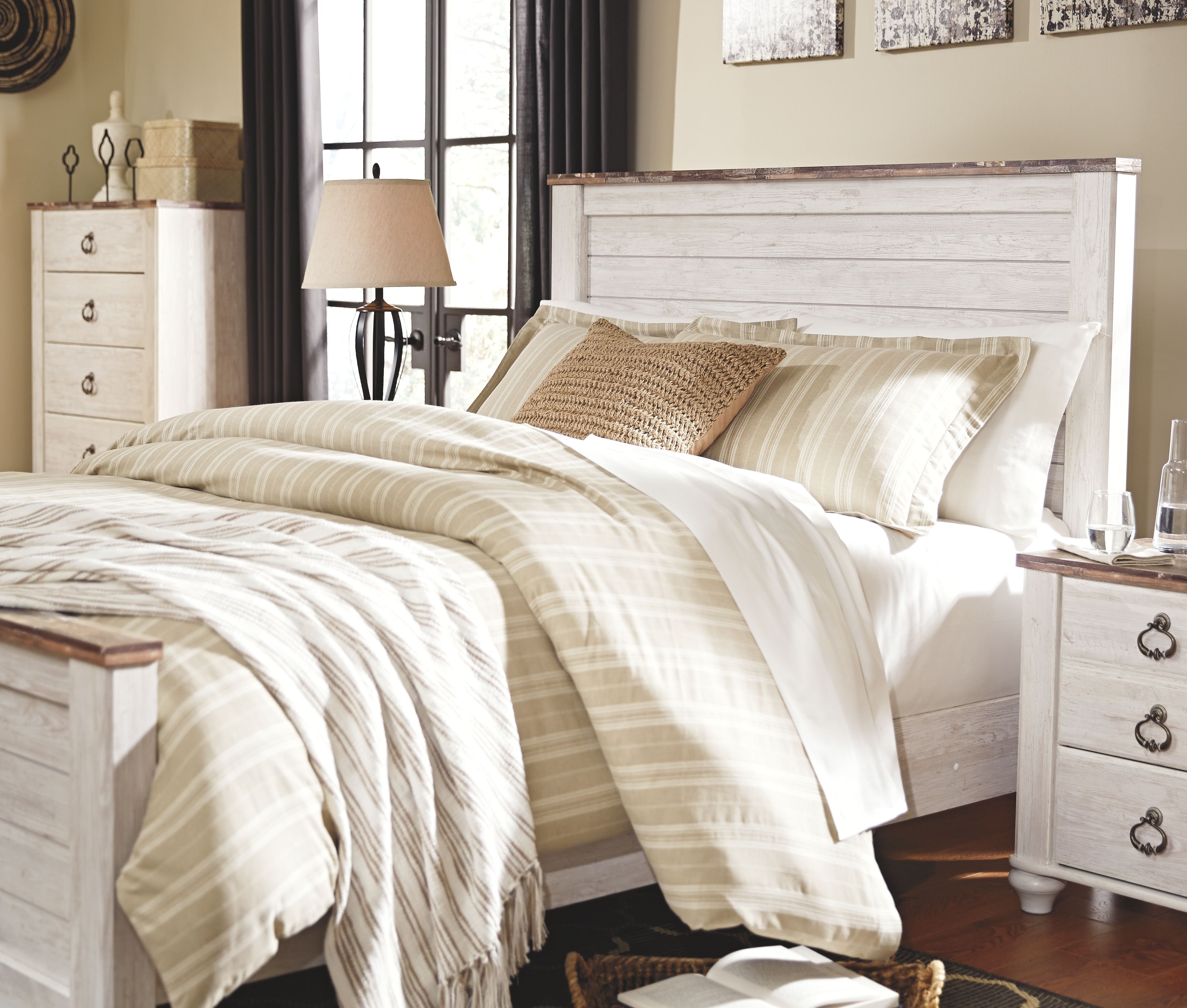 Panel bed with white frame and patterned bedding, with matching nightstand