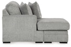 Gray sofa chaise with rounded armrest, chaise seat cushion, and stacked accent pillows