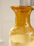 Amber glass vase with flared top, narrow neck, and ombre ivory base