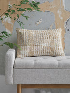 Beige woven lumbar pillow with textured front, placed on seating