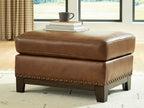 Saonara amber ottoman with studded skirt and dark legs, smooth padded top