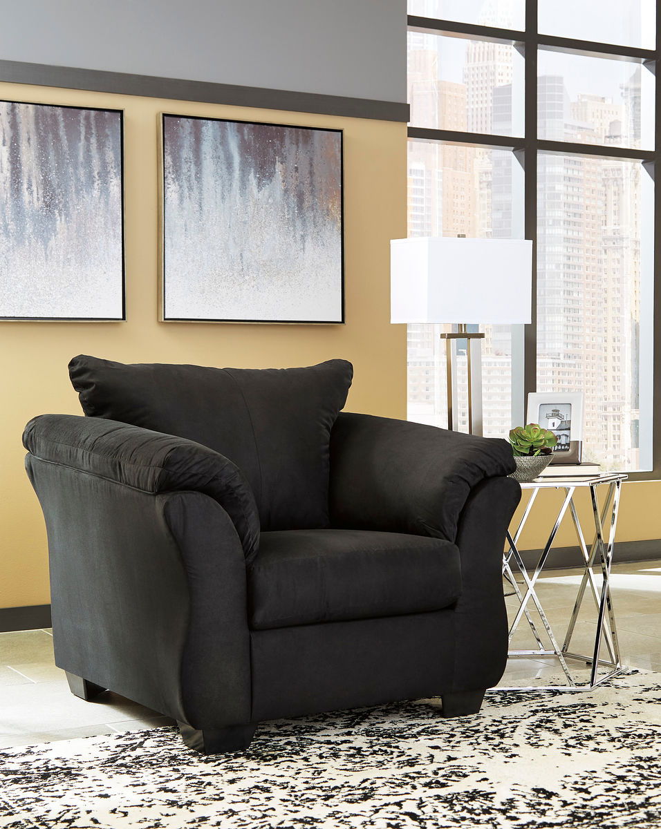 Black upholstered armchair with matching ottoman, plush cushions and rolled arms