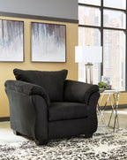 Black upholstered armchair with matching ottoman, plush cushions and rolled arms