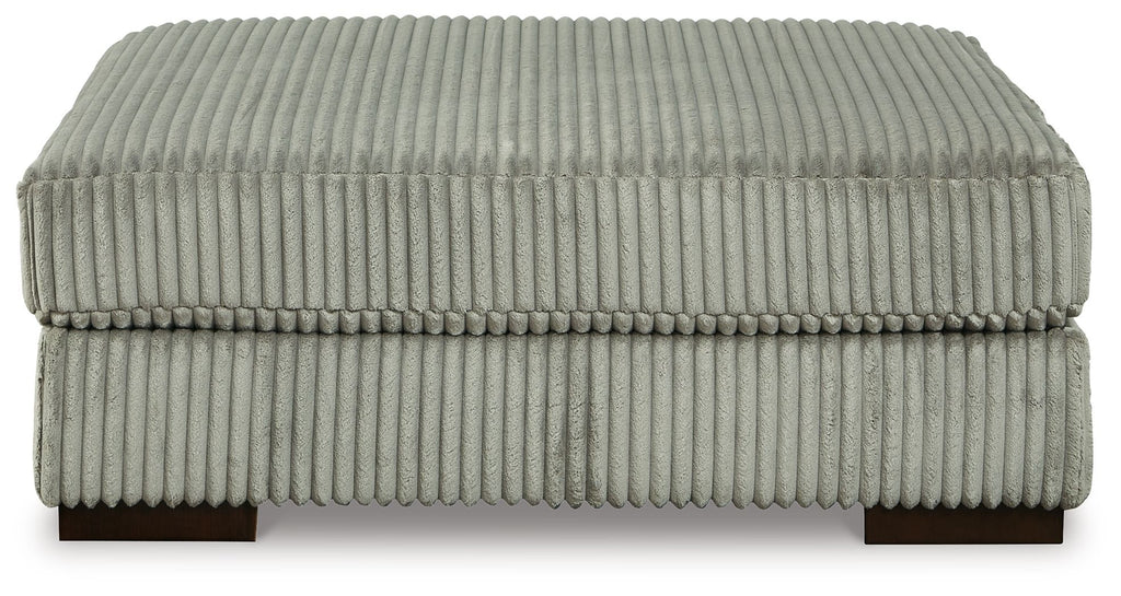 Gray ottoman with ribbed fabric upholstery and rounded square top on short legs