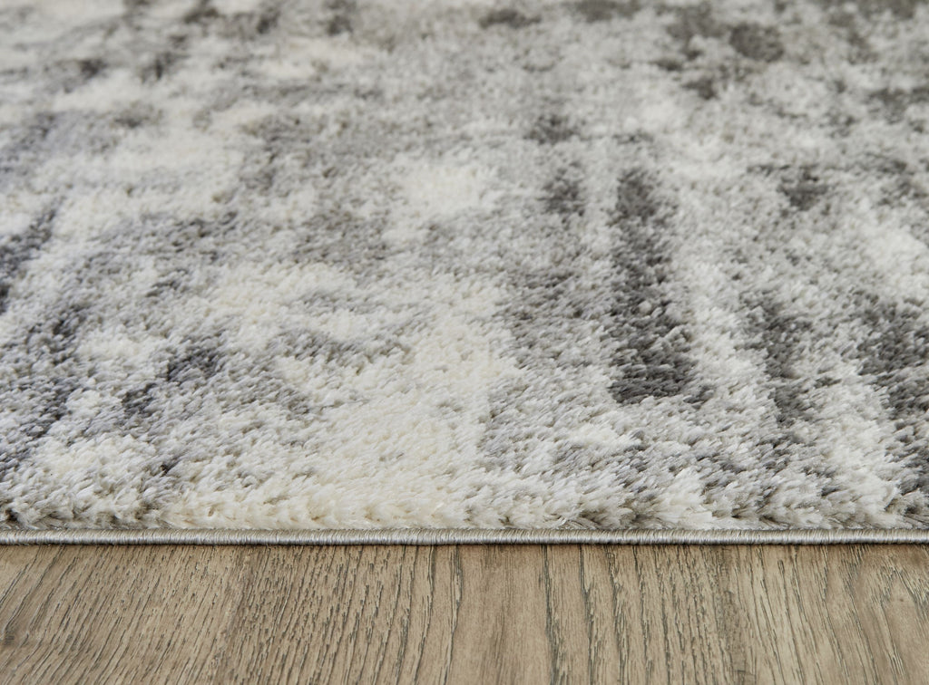 Pearl silver shag rug with distressed abstract pattern and low pile edge