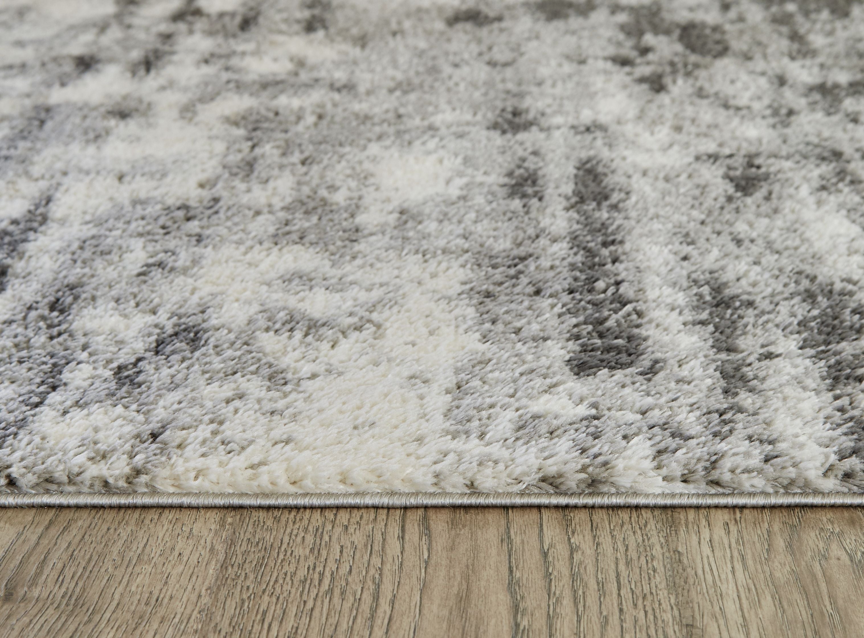 Pearl silver shag rug with distressed abstract pattern and low pile edge