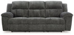 Reclining sofa in gray fabric with tufted back cushions and padded armrests