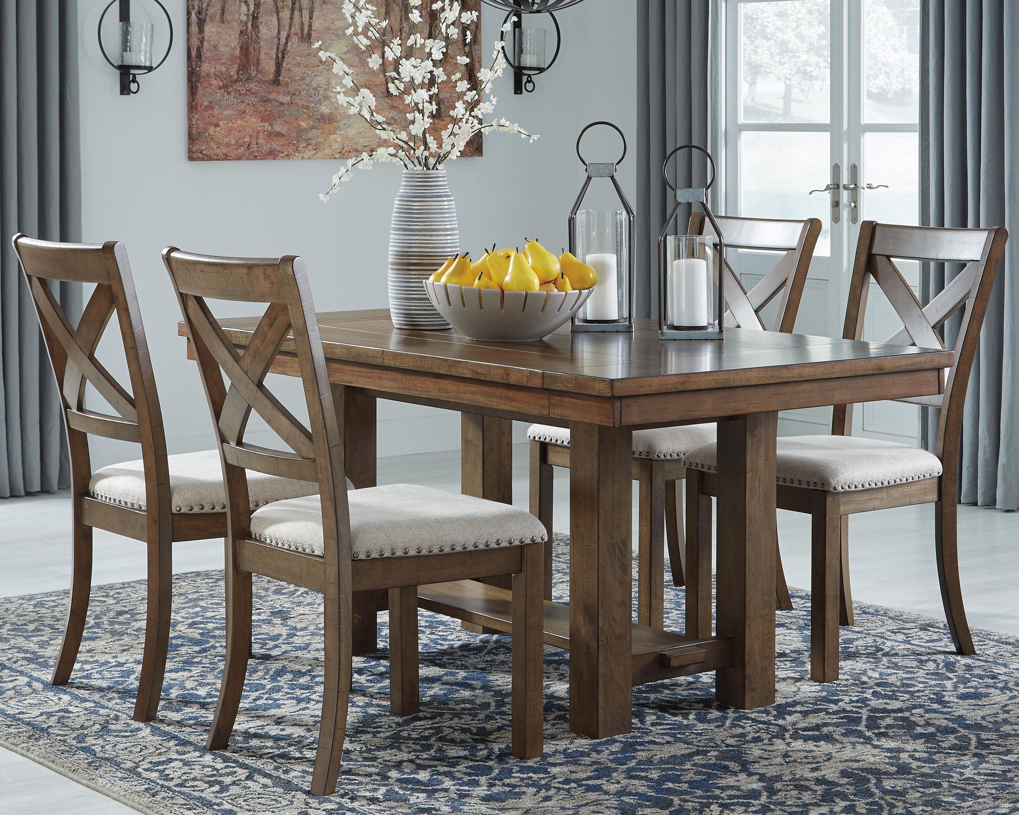 Rectangular dining extension table with four upholstered chairs, gray-brown wood finish.