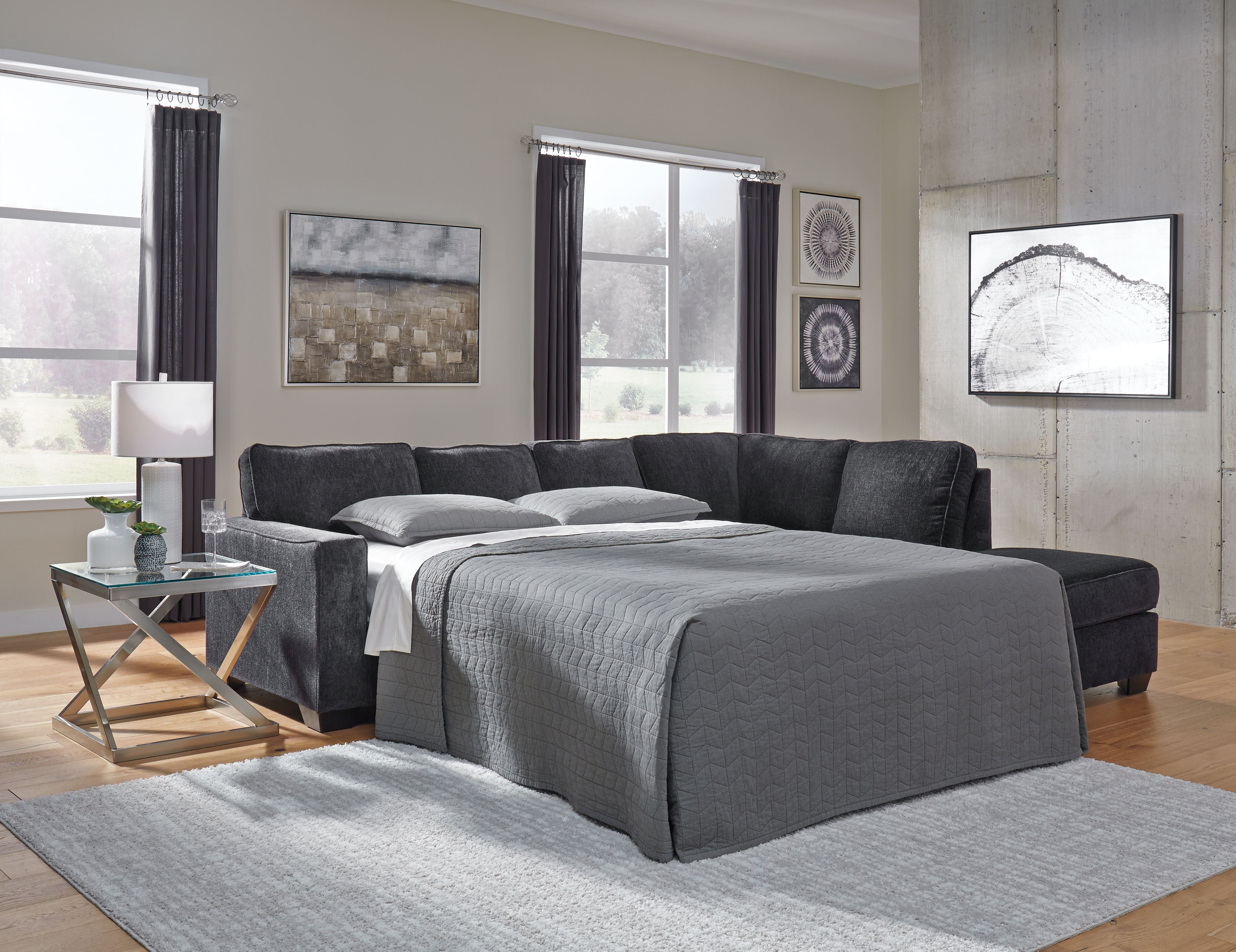 Dark gray sofa sleeper with pull-out bed surface and matching pillows