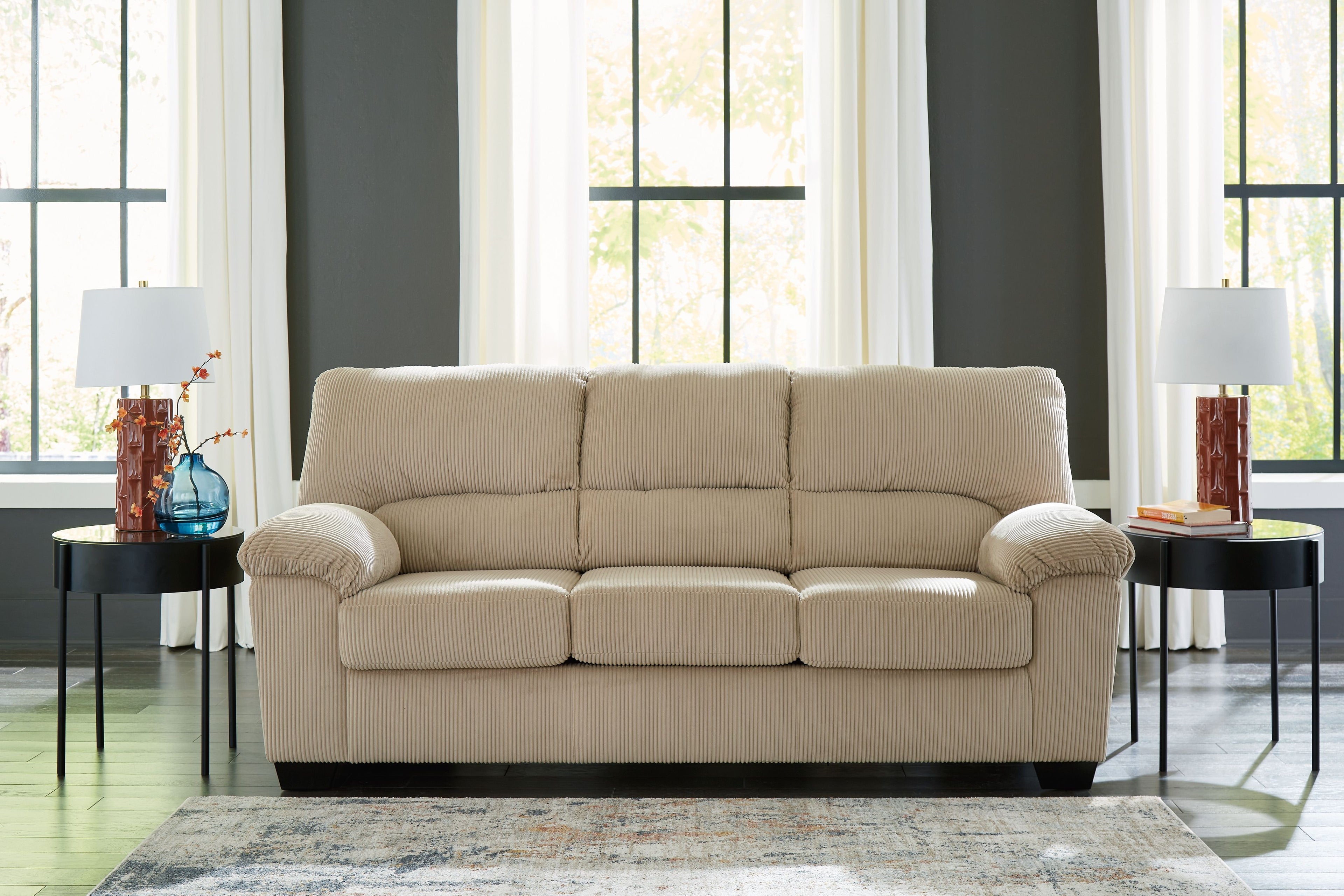 Light beige corduroy sofa with tufted back and three seat cushions