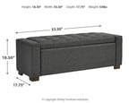 Gray upholstered storage bench with tufted seat cushion and dark wooden feet