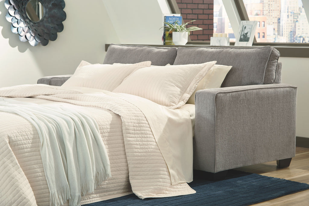 Slate sleeper sofa with extended mattress and white bedding and pillows