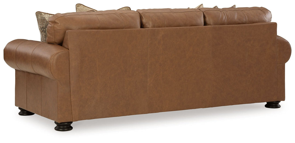 Caramel leather sofa side view with cushioned back and rolled armrests