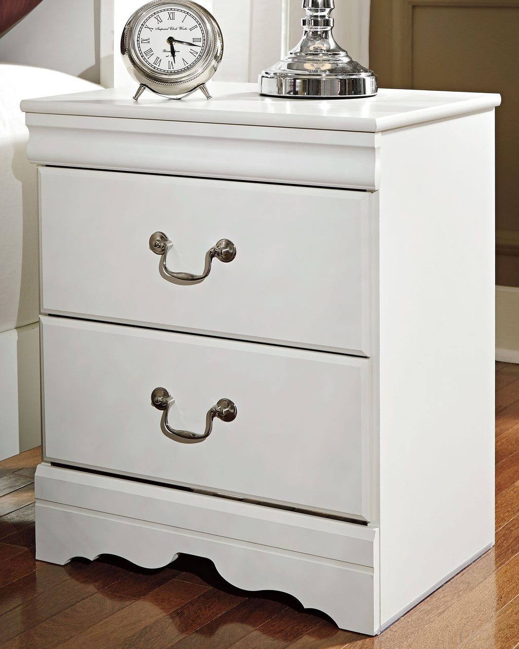 White two-drawer nightstand with two metal drawer pulls and decorative scalloped base