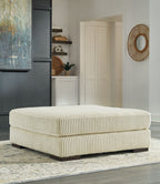 Beige oversized ottoman with ribbed fabric upholstery and rounded square cushion top