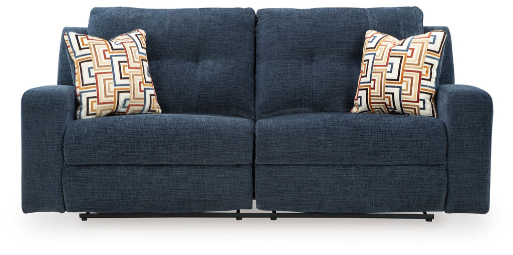 Ink blue 2-seat reclining sofa front view with two armrests and patterned back pillows