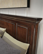 Queen panel headboard close-up in rustic dark brown with decorative trim and panels