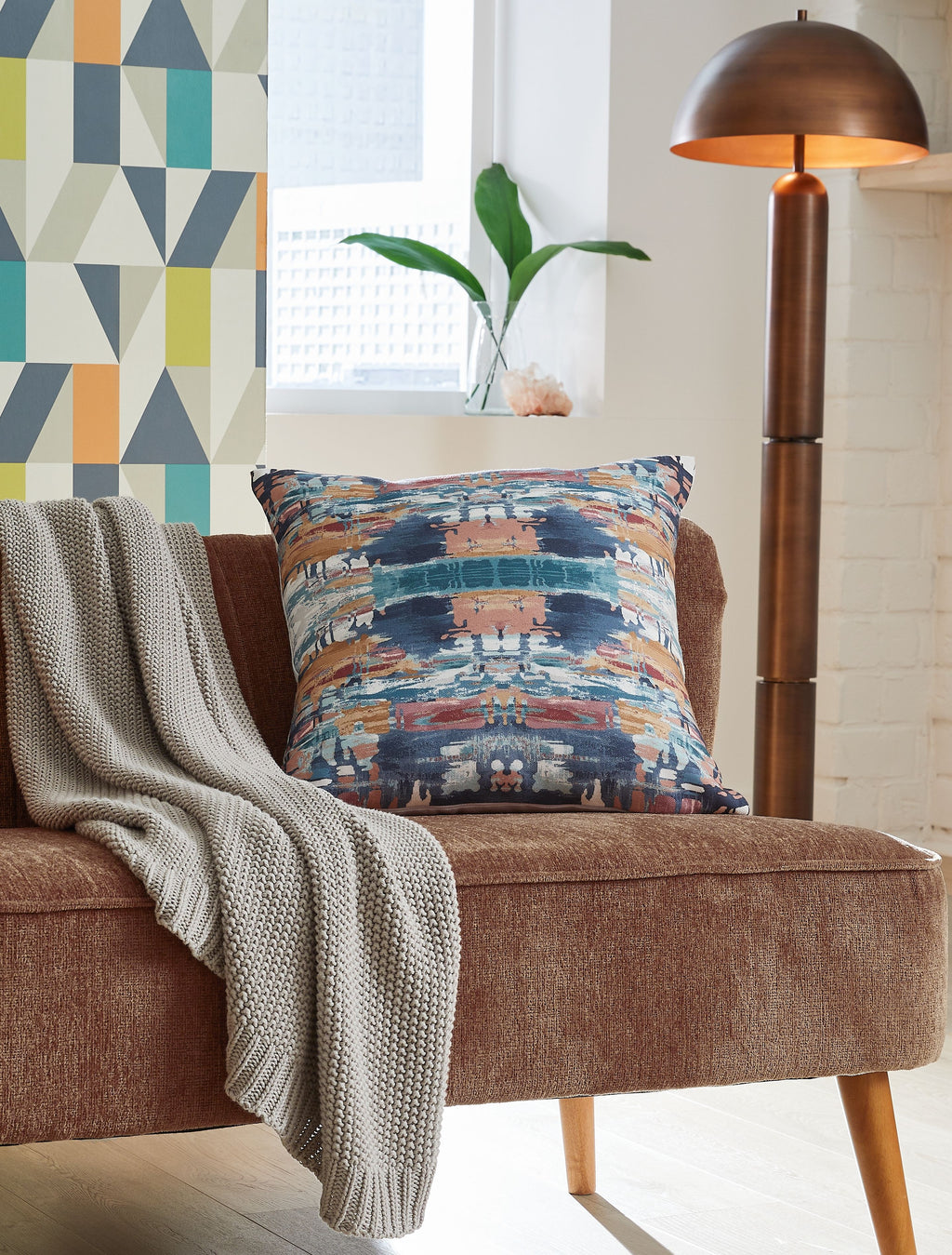 Kennick pillow with blue, tan, and white abstract print on sofa