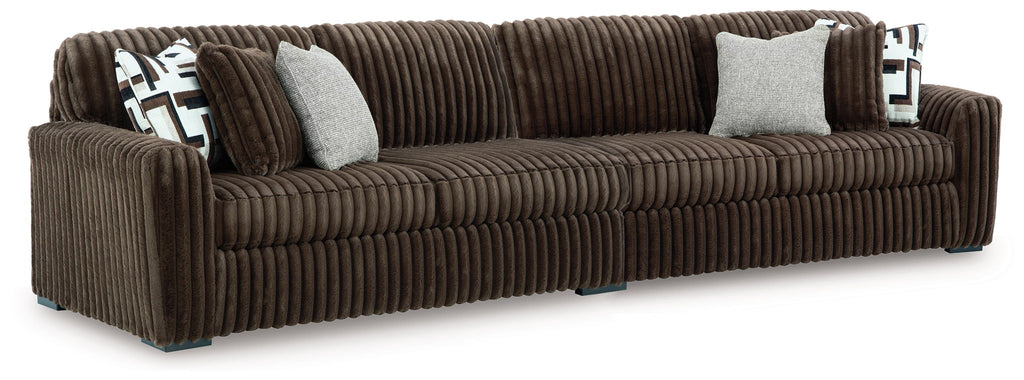 Brown sectional sofa with corner chaise and striped upholstery; includes geometric throw pillows.