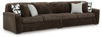 Brown sectional sofa with corner chaise and striped upholstery; includes geometric throw pillows.