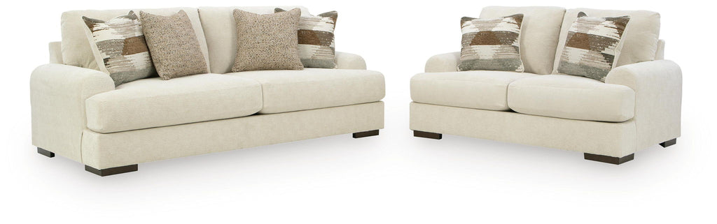 Beige sofa and loveseat set with patterned and solid throw pillows