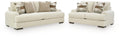Beige sofa and loveseat set with patterned and solid throw pillows