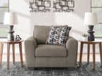 Beige fabric armchair with geometric black-and-white throw pillow