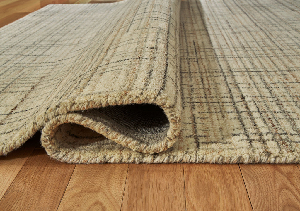 Ivory, gray, tan rug edge with folded underside showing low pile