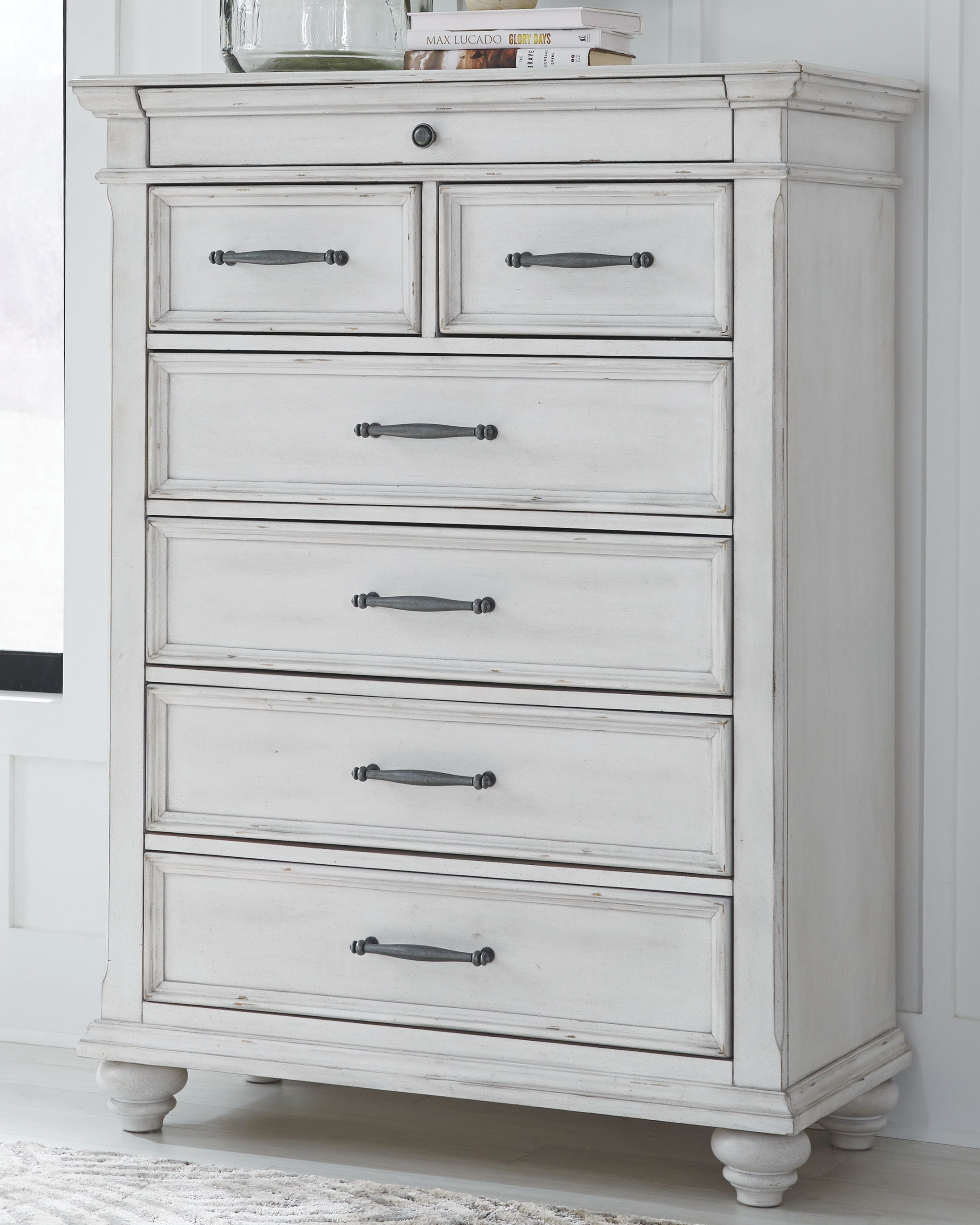 White chest of drawers with five drawers and dark metal bar pulls