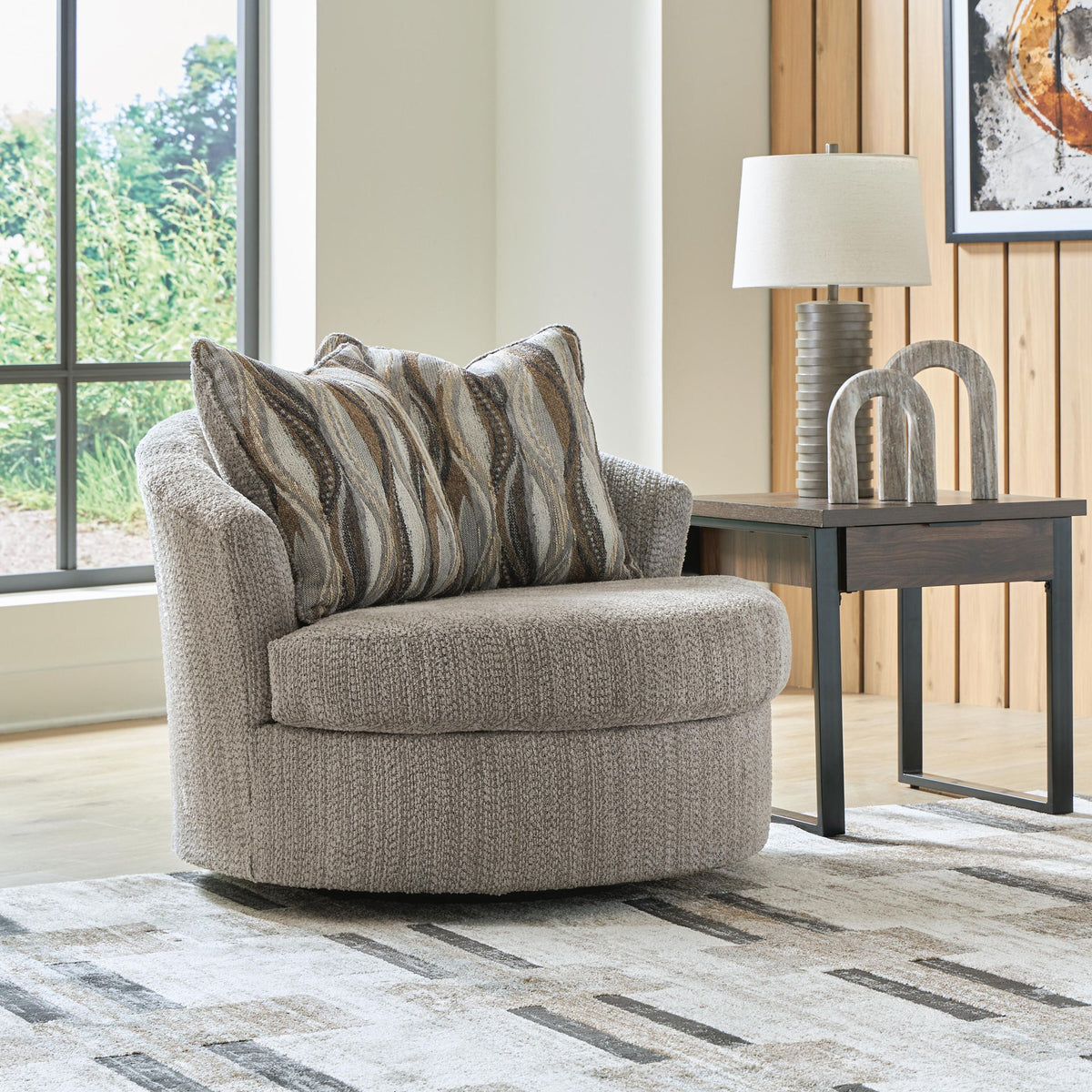 Gray swivel accent chair with two striped throw pillows and cushioned seat
