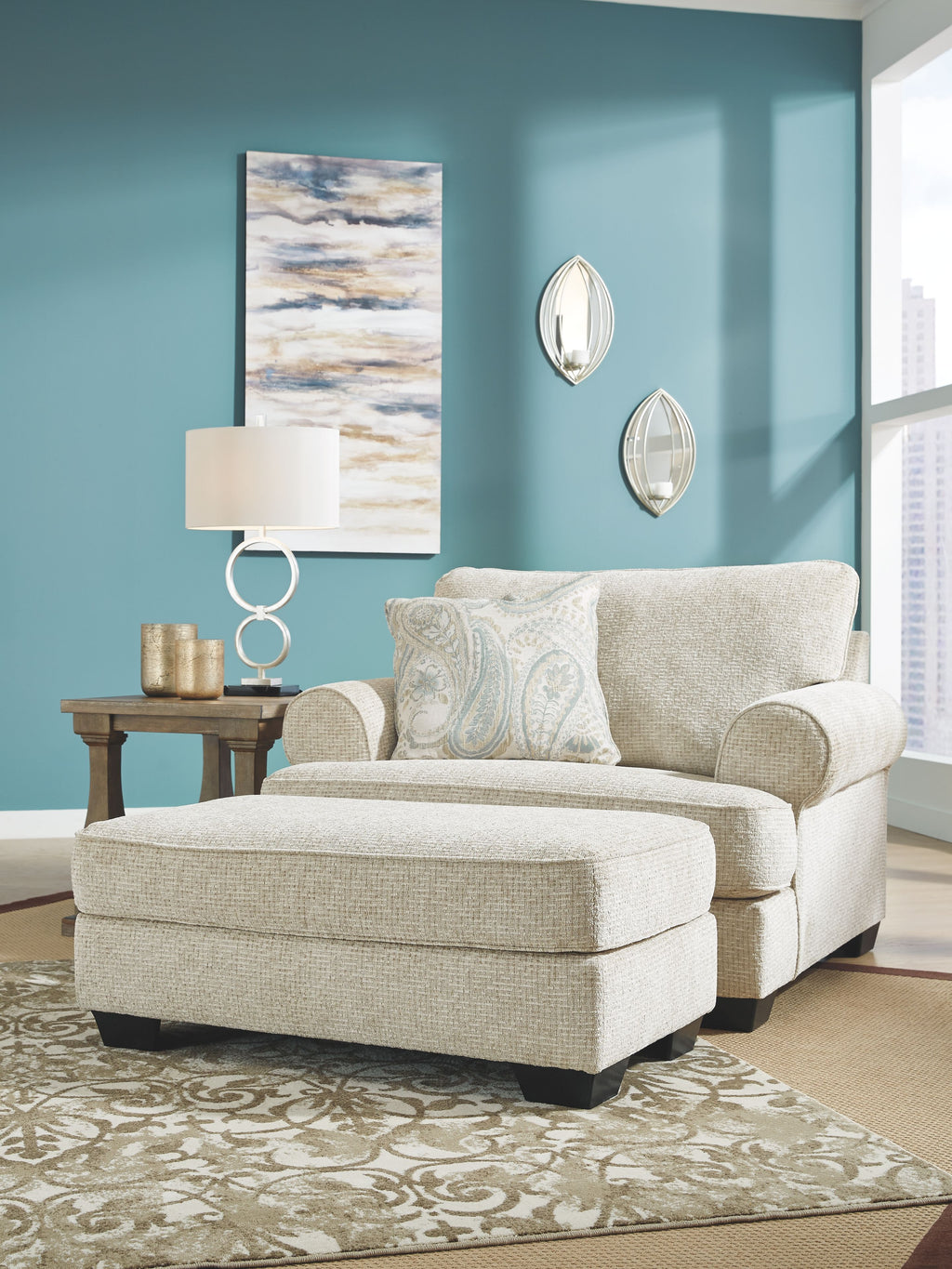 Upholstered loveseat with light beige fabric and two blue patterned pillows